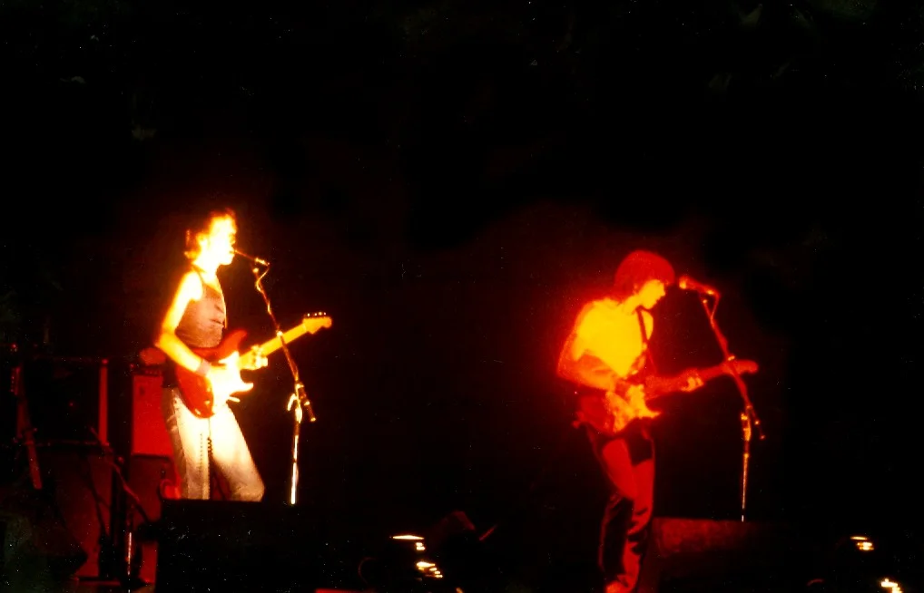 Mark y David Knopfler tocando la guitarra en un escenario, en 1979